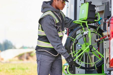 Worker loading a sewer inspection camera.