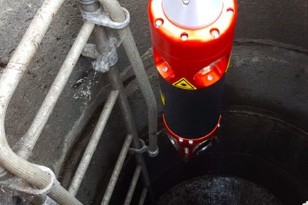 Red and black inspection camera in a manhole.