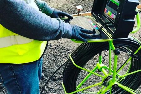 Worker using a sewer inspection camera.